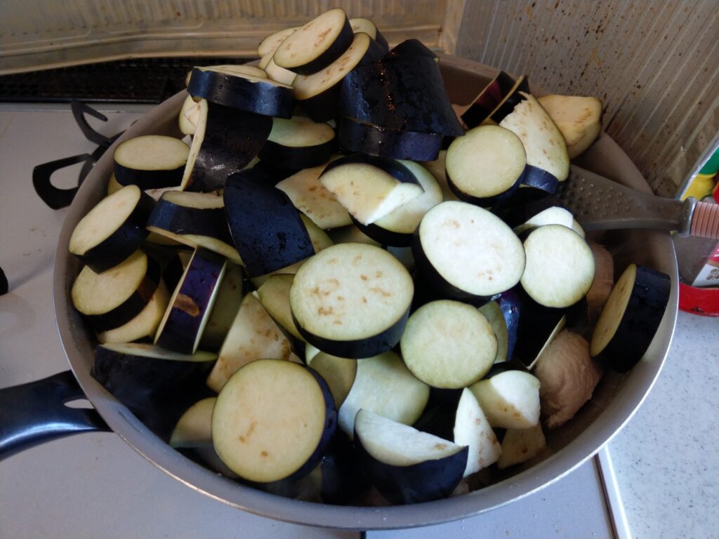 フライパンに鶏むね肉とナスを入れて炒めている。